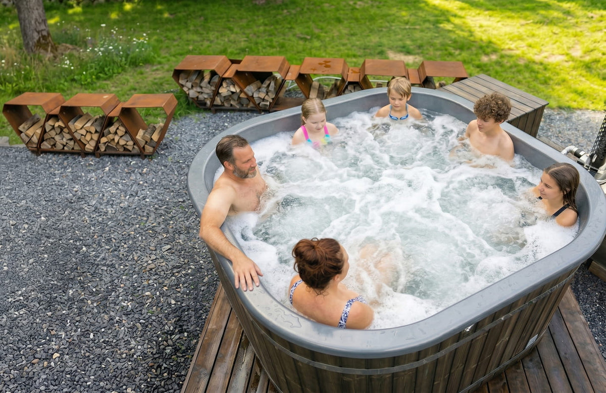 Familie genießt einen Hot Tub im Außenbereich mit einer Feuerstelle aus Holz im Hintergrund