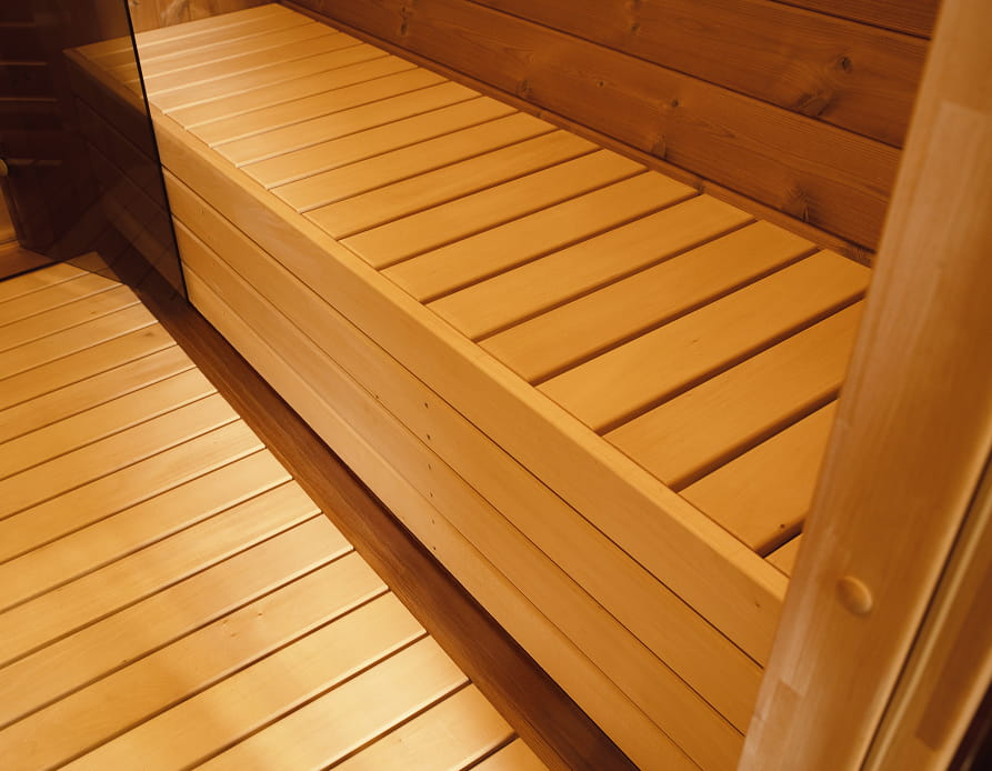 Showcasing the inside of a wooden barrel sauna.
