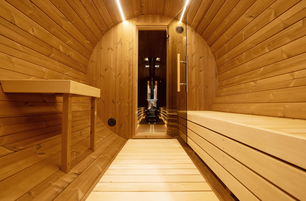 Showcasing the inside of a wooden barrel sauna.