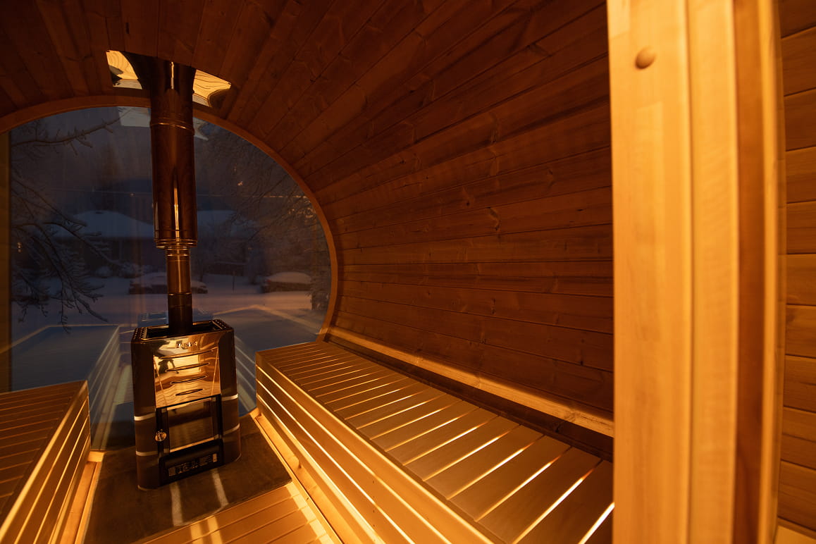 Showcasing the inside of a wooden barrel sauna.