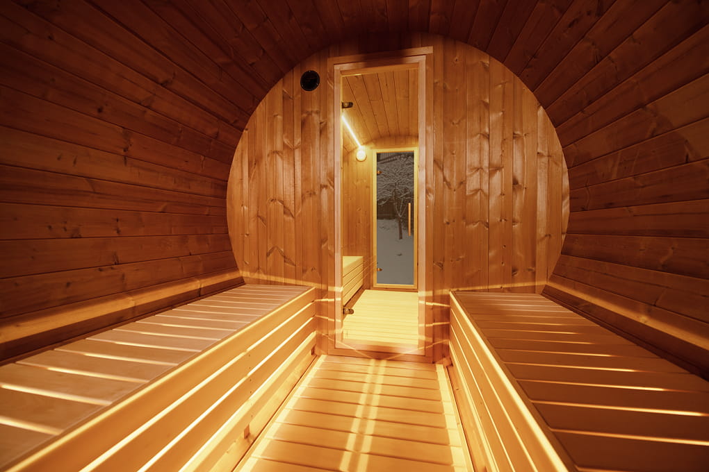Showcasing the inside of a wooden barrel sauna.