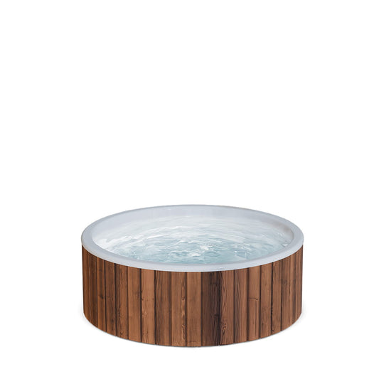Ein runder Whirlpool im Freien mit flachem Boden und hellem Innenraum, gefüllt mit Wasser, vor einem schlichten weißen Hintergrund.