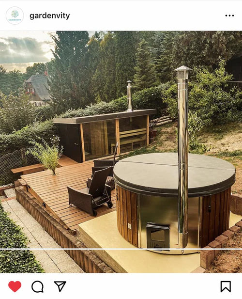 Outdoor wooden hot tub with cover on a raised deck beside a house, showcasing clean installation and garden relaxation space.