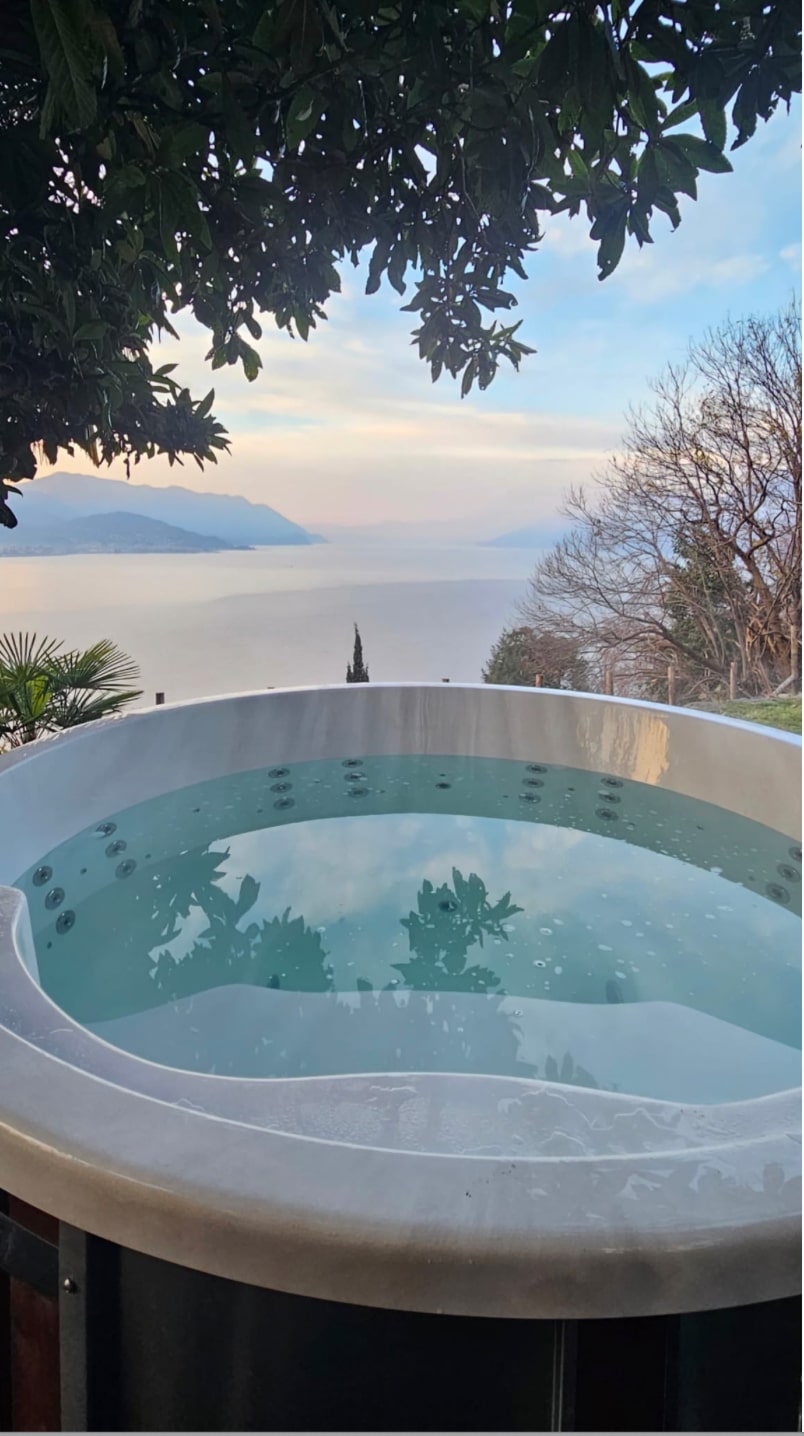 Runder Gardenvity hot tub mit Seeblick in Italien – minimalistisches Outdoor-Setup.