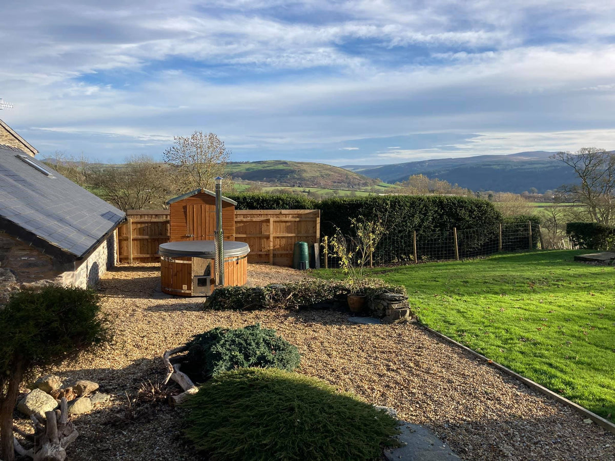 Gardenvity hot tub mit malerischen Hügeln im Hintergrund – authentisches Kundenfoto.