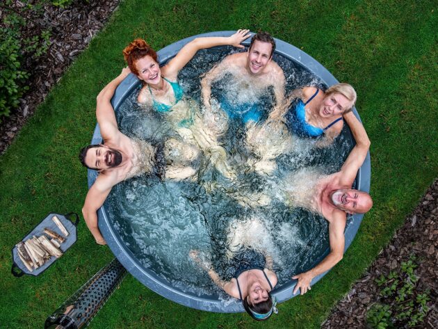 6 Personen entspannen in einem holzbefeuerten Hot Tub von Gardenvity mit integrierter Holzofen