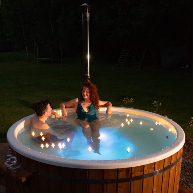 Zwei Menschen entspannen sich in einem Hot Tub mit mehrfarbigen Lichtpunkten nachts